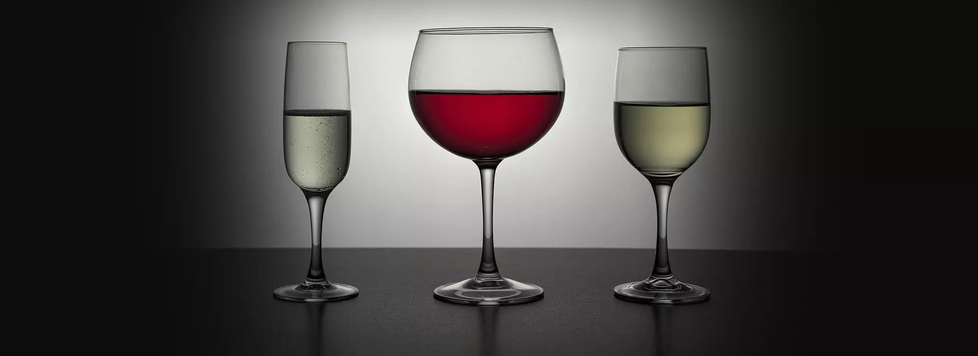 Drei Gläser mit Sekt, Rotwein und Weisswein.